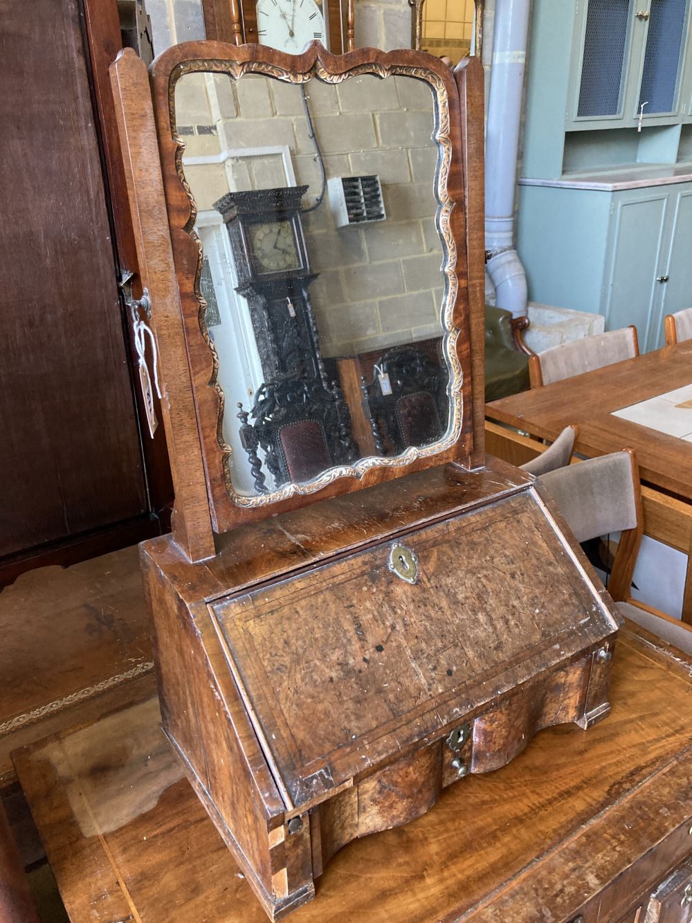 An early 18th century walnut toilet mirror, the base enclosed by fall front over drawer, width 46cm, depth 30cm, height 74cm